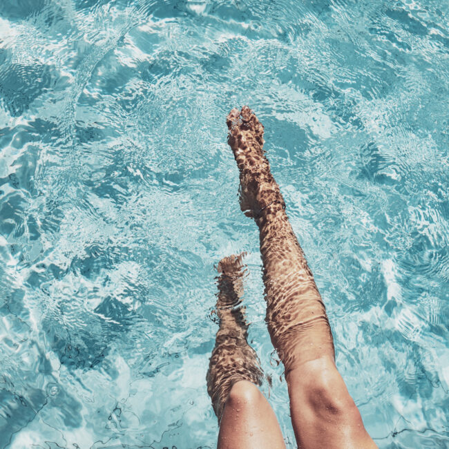 Highangle view of beautiful legs in a splashing pool