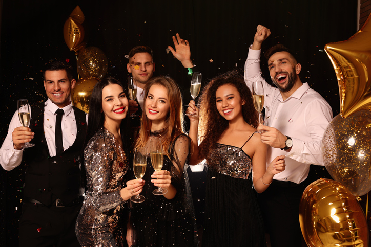 group of men and women dressed up for new years eve celebration
